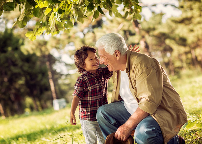 Photo featuring an elderly man outside with his grandson.